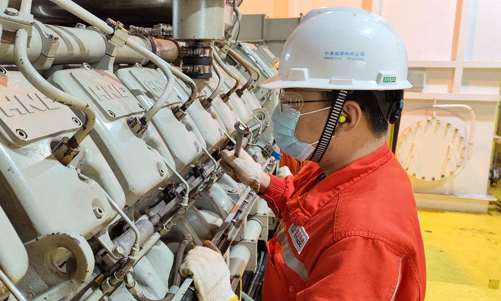荔灣3-1平臺積極推動數(shù)智化建設(shè)，為氣田安全穩(wěn)定生產(chǎn)注入科技動能。平臺與陸岸終端建立超遠(yuǎn)距離通信，借助視頻監(jiān)控、巡檢機(jī)器人、激光氣體檢測等技術(shù)，實(shí)現(xiàn)陸地遠(yuǎn)程操控海上平臺生產(chǎn)，進(jìn)一步增強(qiáng)臺風(fēng)無人生產(chǎn)模式的安全性與可靠性。圖為工作人員開展應(yīng)急發(fā)電機(jī)維保作業(yè)。
