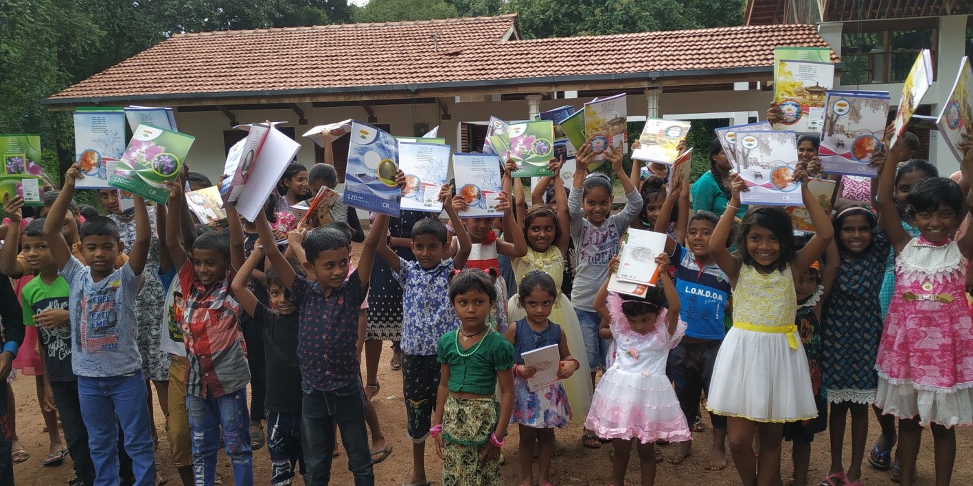 斯里蘭卡SHINNING STARS兒童公益學校的孩子們向鏡頭展示他們收到的新書.jpg