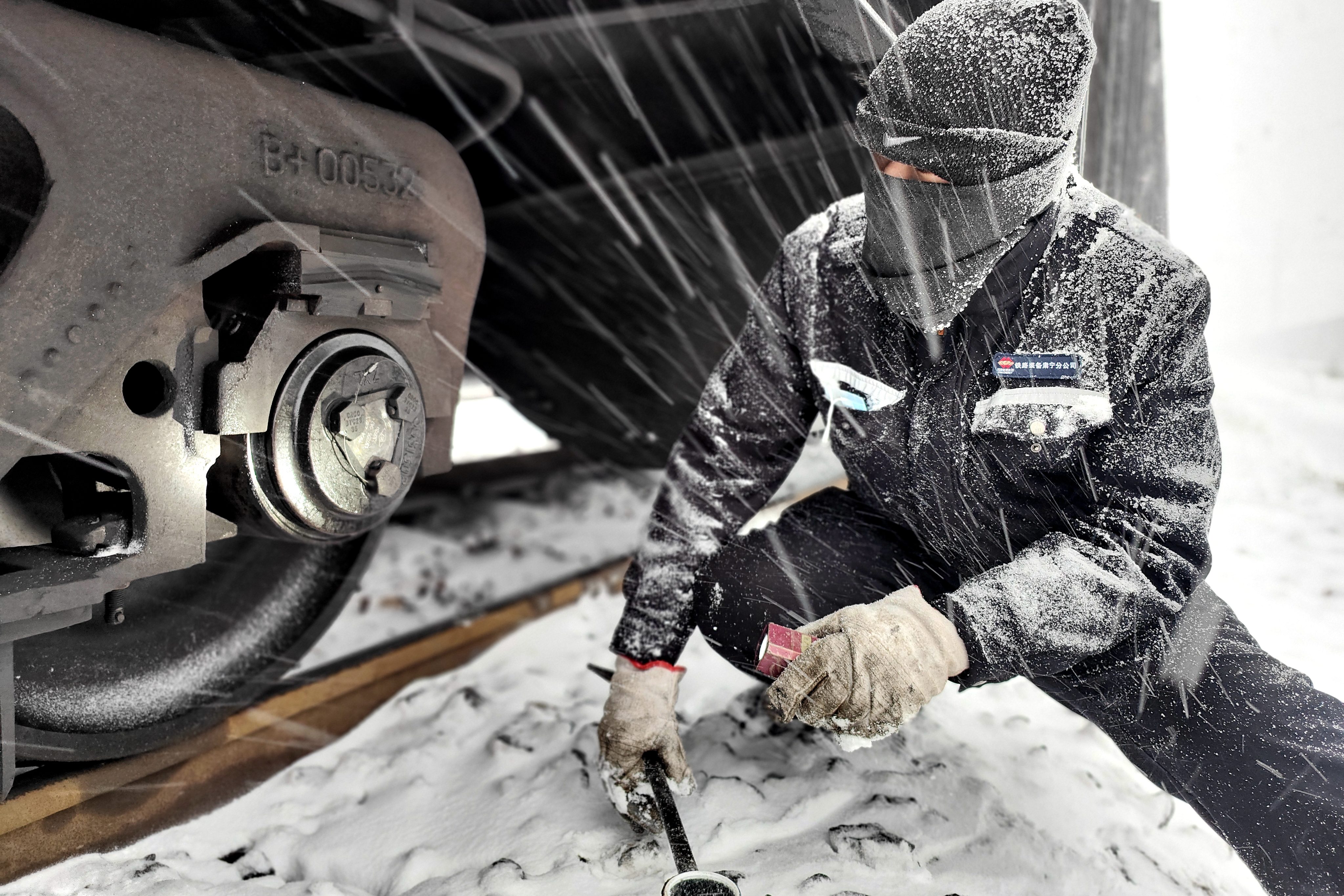 圖為1月20日鐵路裝備肅寧分公司肅寧北列檢作業場檢車員冒雪對車輛軸承部位進行檢查-王建_副本.jpg