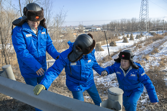 圖為員工翻越管道和橋梁交界處，檢查原油管道運(yùn)行情況。王志強(qiáng) 攝.jpg