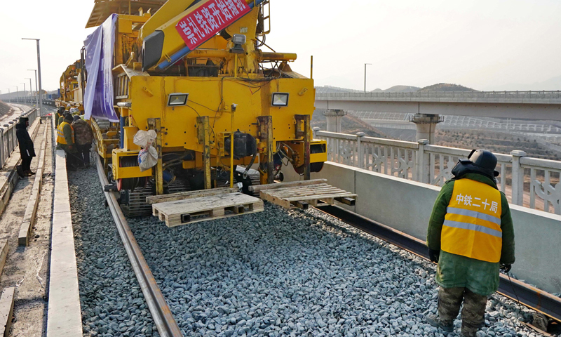 1月6日，由中鐵二十局承建的2022年北京冬奧會配套保障工程——崇禮鐵路鋪軌工程在張家口市下花園區(qū)戴家營大橋展開。圖為工人在崇禮鐵路張家口市下花園區(qū)戴家營大橋鋪軌現(xiàn)場工作。（新華社記者 楊世堯 攝）