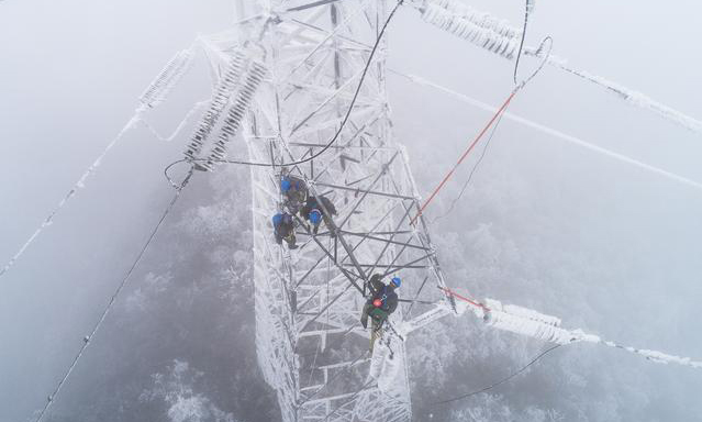 圖為2月12日，國(guó)網(wǎng)武漢市黃陂區(qū)供電公司工作人員在進(jìn)行搶修作業(yè)。（新華社記者 肖藝九 攝）