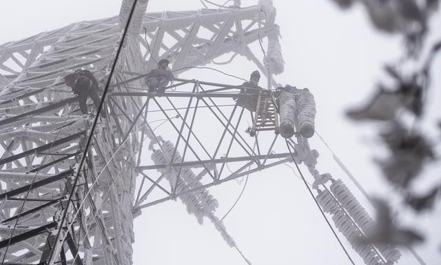 圖為2月12日，國(guó)網(wǎng)武漢市黃陂區(qū)供電公司工作人員在進(jìn)行搶修作業(yè)。（新華社記者 肖藝九 攝）