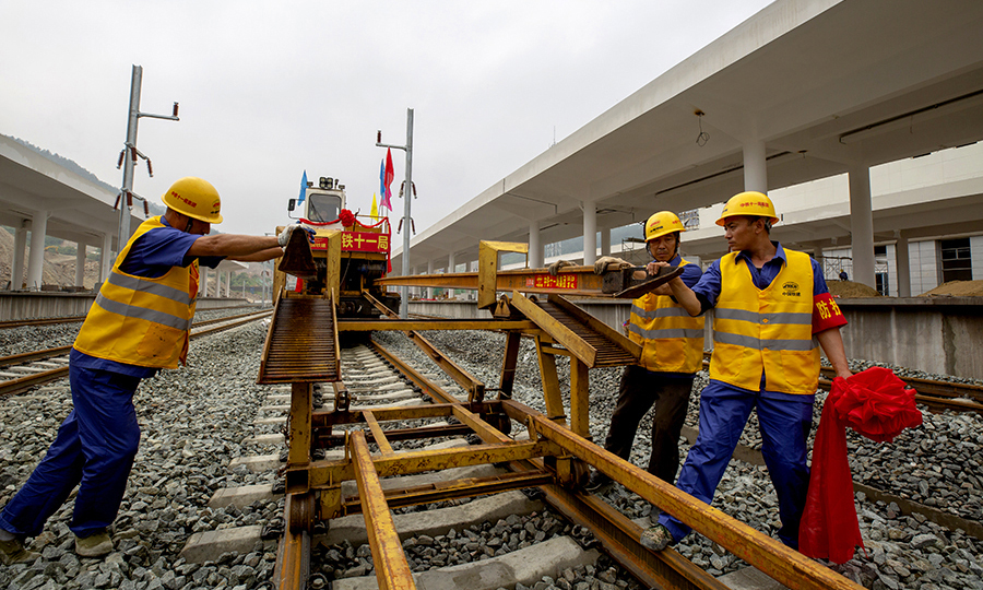 漢十高鐵是武（漢）西（安）高鐵的重要組成部分，也是《國(guó)家中長(zhǎng)期鐵路網(wǎng)規(guī)劃》中福（州）銀（川）高鐵的重要組成部分，自漢孝城際鐵路孝感東站引出，經(jīng)隨州、襄陽(yáng)至十堰，線路全長(zhǎng)399公里，設(shè)計(jì)時(shí)速350公里。中鐵十一局三公司擔(dān)負(fù)漢十高鐵全線的鋪軌施工任務(wù)。圖為鋪軌施工現(xiàn)場(chǎng)。（彭特 攝）