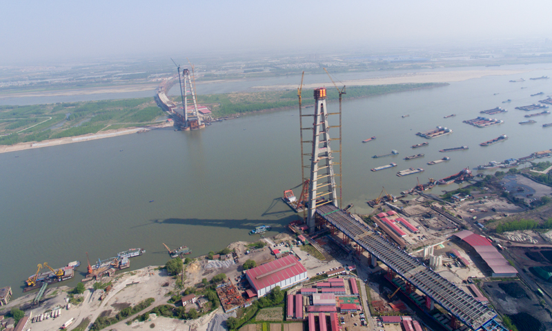 這也標志著由中鐵大橋院設計、中鐵大橋局施工的世界上跨度最大的雙塔鋼箱及鋼箱結合梁斜拉橋建設取得階段性勝利。圖為4月10日，武漢青山長江大橋南岸主塔成功封頂（無人機拍攝）。