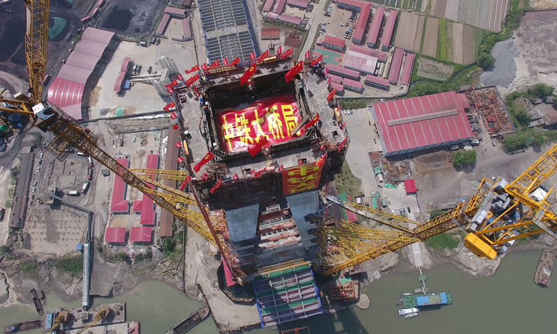 武漢青山長江大橋位于武鋼外貿港碼頭下游1公里處，全長7548米，大橋設計為雙向10車道（預留兩車道）高速公路，設計時速100公里。圖為4月10日，武漢青山長江大橋南岸主塔成功封頂（無人機拍攝）。