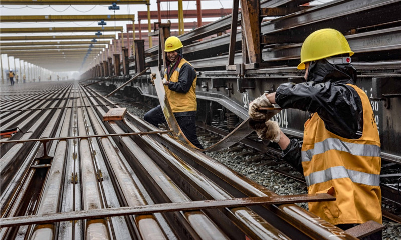 隨著漢十高鐵進入緊張的攻堅階段，承擔漢十高鐵全線鋪軌施工的中鐵十一局三公司已經全面展開長軌運輸、存儲、焊接等工作。目前，該公司漢十高鐵棗陽鋪軌基地已經存儲長軌262.5公里，為漢十高鐵全線長軌鋪設奠定了基礎。圖為5月5日，中鐵十一局職工在漢十高鐵棗陽鋪軌基地存軌區安放扁鐵，為堆碼500米長軌做準備。（新華社記者 杜華舉 攝）